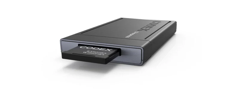 Карта пам'яті Codex CFexpress частково вставлена ​​в сірий кардрідери Codex на білому тлі.
