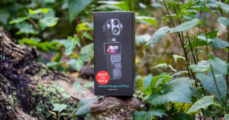 Чорна коробка для Xtra Muse 2 Pro Vlog Combo лежить на стовбурі дерева в лісистій місцевості, з наліпкою "НЕ ДЛЯ ПРОДАЖУ".