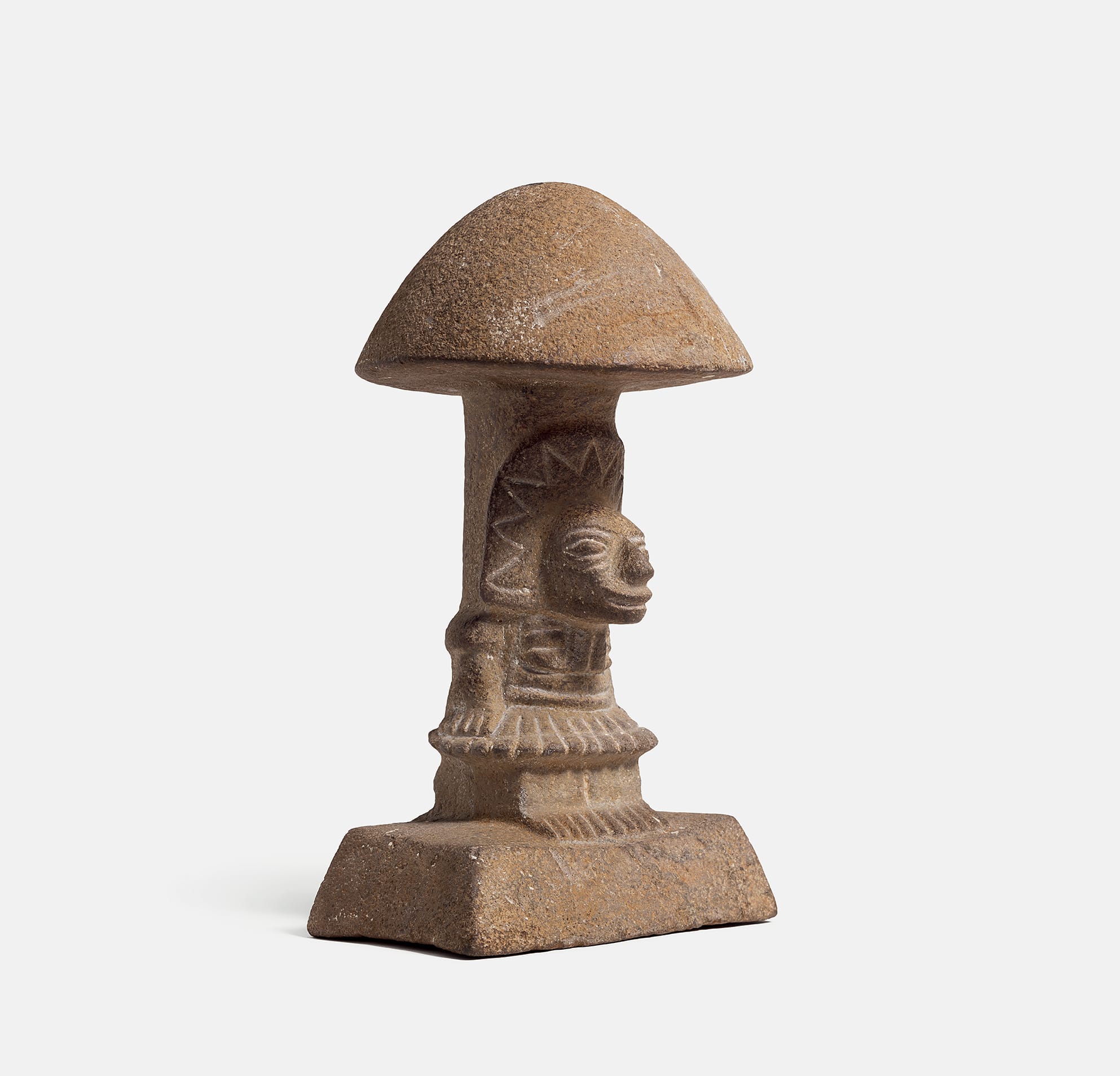 a carved stone sculpture of a mythic figure emerging from a mushroom