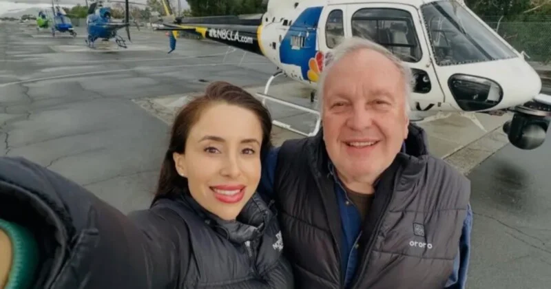 Жінка та літній чоловік роблять селфі перед гелікоптером NBCLA на летовищі.