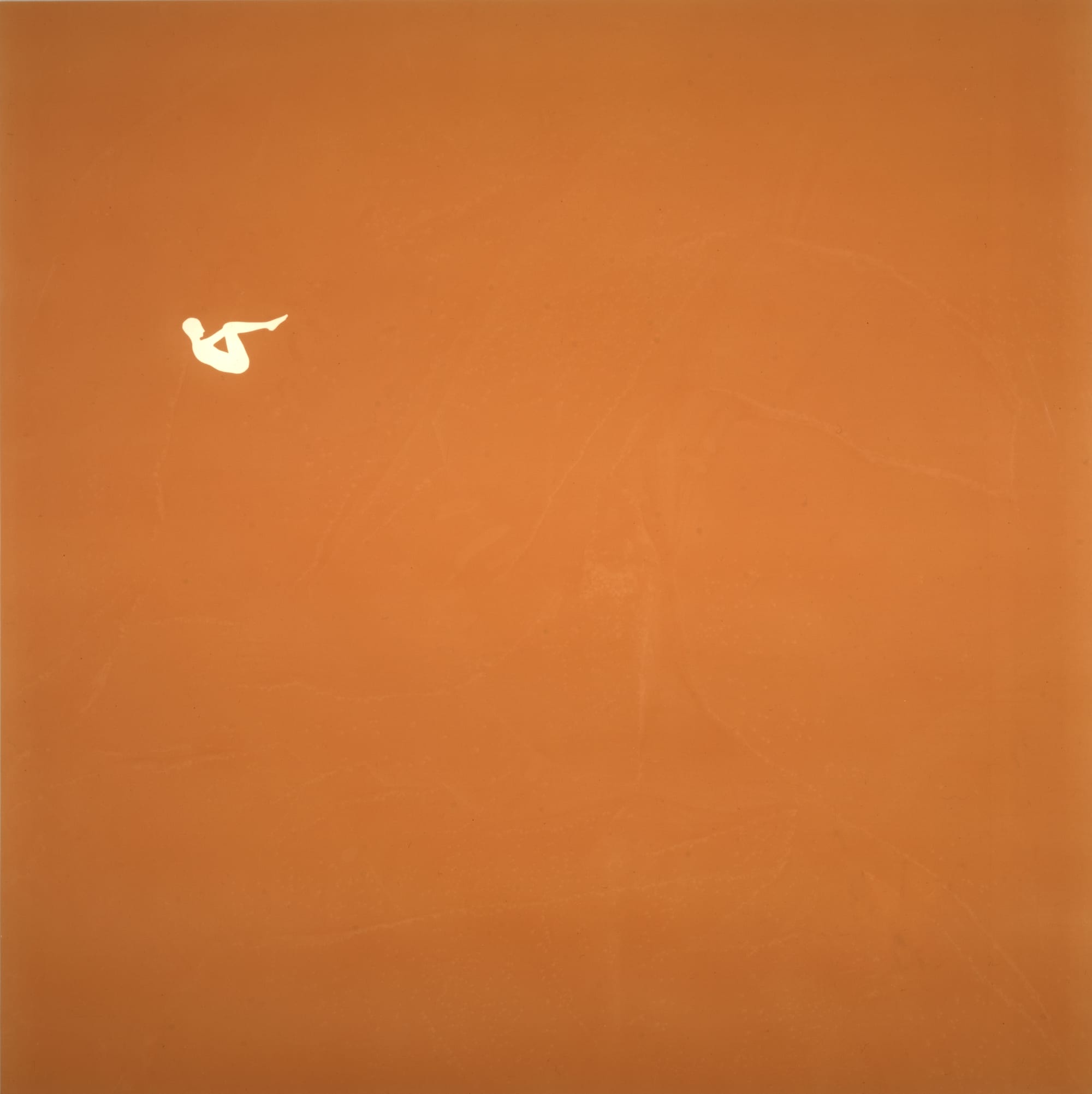 a small figure in white against a vast orange backdrop