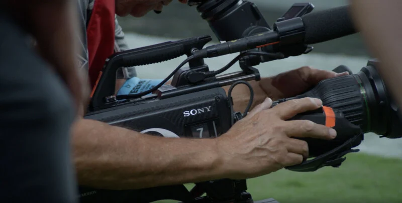Руки людини керують професійною відеокамерою Sony, на корпусі якої видно номер 7.