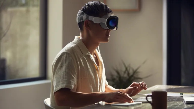 Жінка в гарнітурі доповненої реальності Apple Vision Pro.
