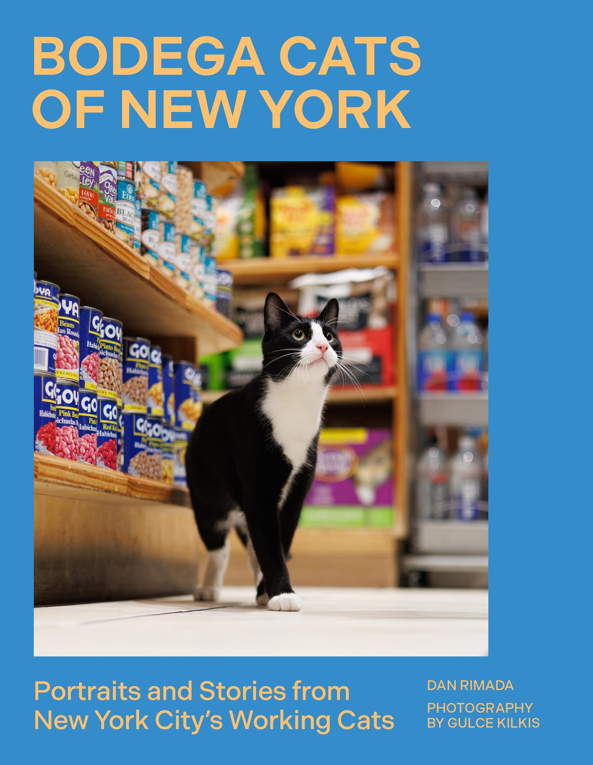 обкладинка книги під назвою 'Bodega Cats of New York' з синім тлом і фотографією чорно-білого кота в бодезі в Нью-Йорку