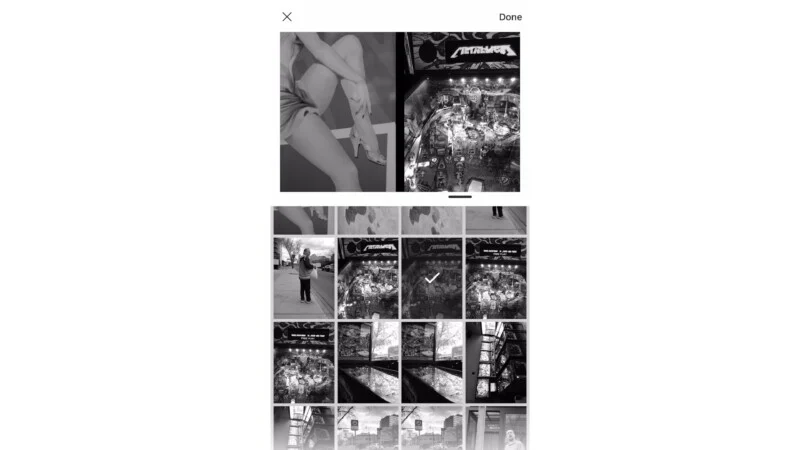Екран телефону відображає галерею вибору фотографій у чорно-білому кольорі, показуючи кілька зображень, включаючи витвори мистецтва, пінбольні автомати, людину, що стоїть на вулиці, та міські пейзажі. Вибрано одне фото пінбольного автомата.